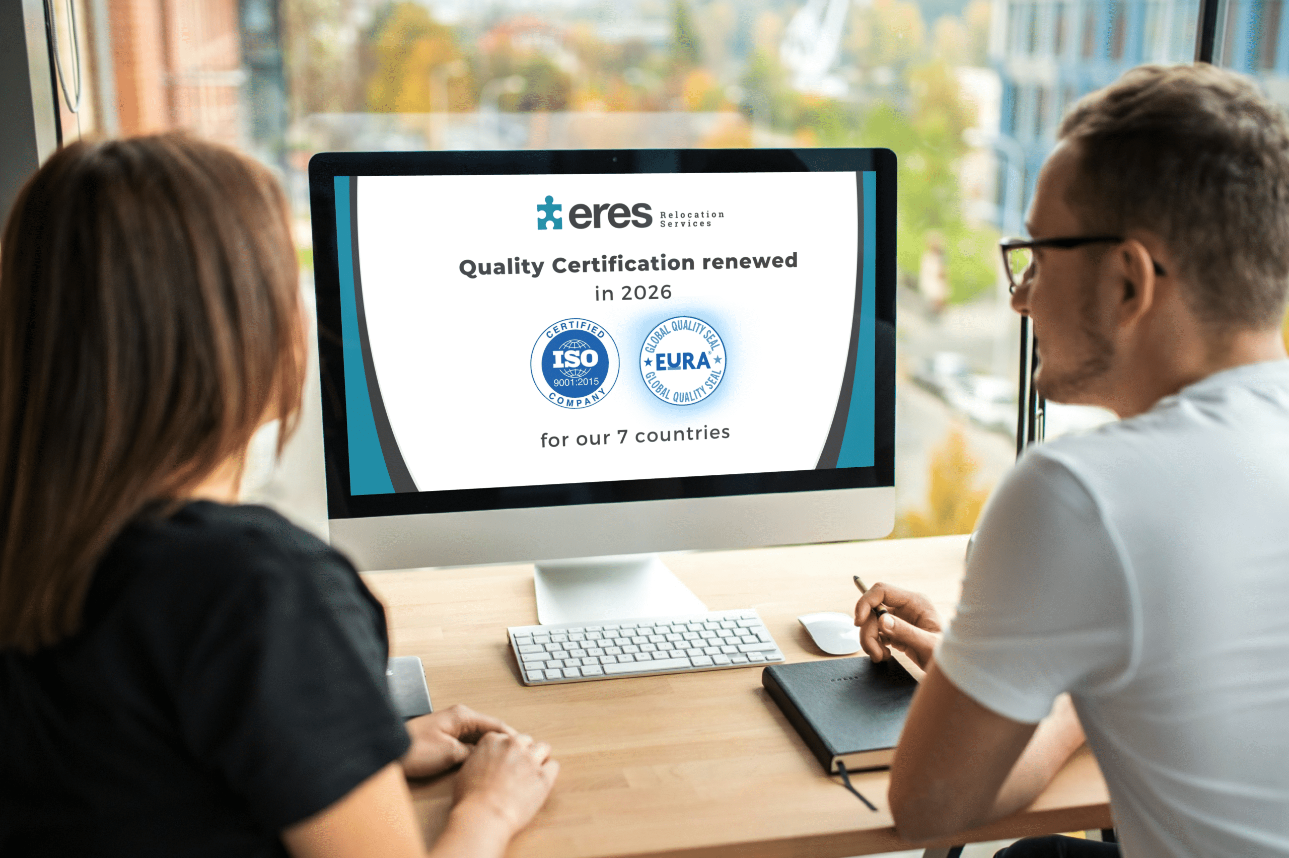 Employees reviewing ISO 9001:2015 and EuRA Global Quality Seal certifications on a computer screen, representing quality and compliance in relocation services