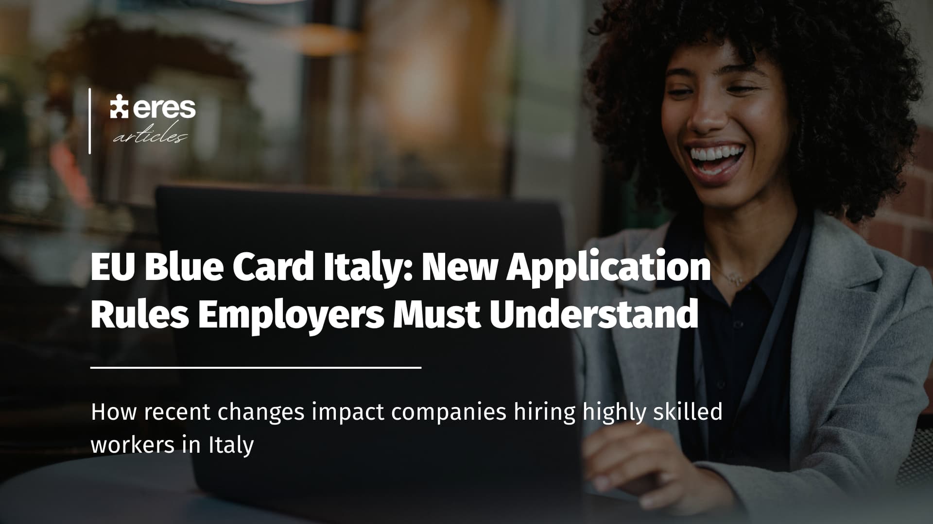 Young international professional smiling while working on a laptop, representing highly skilled talent in Italy